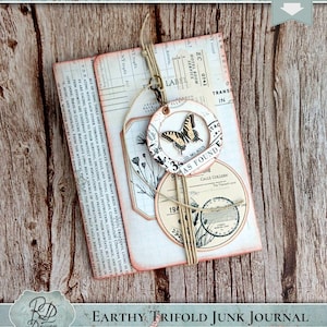 May include: Earthy trifold junk journal with a butterfly design. The journal features a layered design with tags, circles, and botanical illustrations. The color palette includes cream, peach, and brown tones, with text elements.