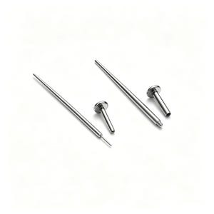 May include: Two silver-coloured metal body piercing tapers and two matching flat-back labret studs. The tapers are long, thin, and pointed at one end, while the labret studs feature a circular flat disc head and a hollow cylindrical post.