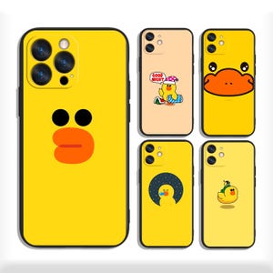 Può includere: Una collezione di custodie per telefoni gialle e color pesca con disegni di anatre dei cartoni animati. Le custodie presentano varie grafiche a tema anatra, tra cui una faccia di anatra, un'anatra con un berretto da notte e un'anatra sotto un cielo stellato.