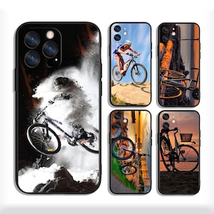 May include: Black phone case with images of bicycles and cyclists. One case shows a cyclist mid-air, another shows a cyclist on a mountain, and others show bicycles in scenic locations. The cases are designed for a smartphone.