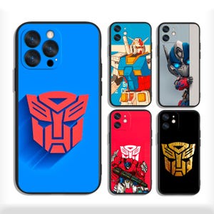 May include: A selection of phone cases with diverse designs. One case is blue with a red Transformers logo. Other cases feature robot characters in various colours. The cases have black borders and are for smartphones.