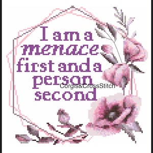 May include: Cross-stitch design with the text "I am a menace first and a person second" in purple. The text is inside a pink geometric frame, with pink floral accents and the shop name "Corgis&CrossStitch".