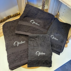 Pode incluir: Quatro toalhas de cor cinza escuro com bordado branco que diz "Ofeline" em cada toalha.