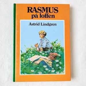 Puede incluir: Una cubierta de libro vintage de color naranja y verde con el t&iacute;tulo "RASMUS p&aring; loften" y el autor "Astrid Lindgren". La cubierta presenta una ilustraci&oacute;n de un ni&ntilde;o sentado en un campo de margaritas con un hombre acostado en la hierba.