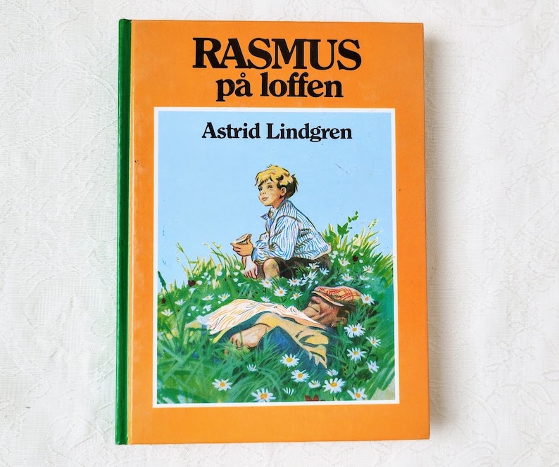 Puede incluir: Una cubierta de libro vintage de color naranja y verde con el t&iacute;tulo "RASMUS p&aring; loften" y el autor "Astrid Lindgren". La cubierta presenta una ilustraci&oacute;n de un ni&ntilde;o sentado en un campo de margaritas con un hombre acostado en la hierba.