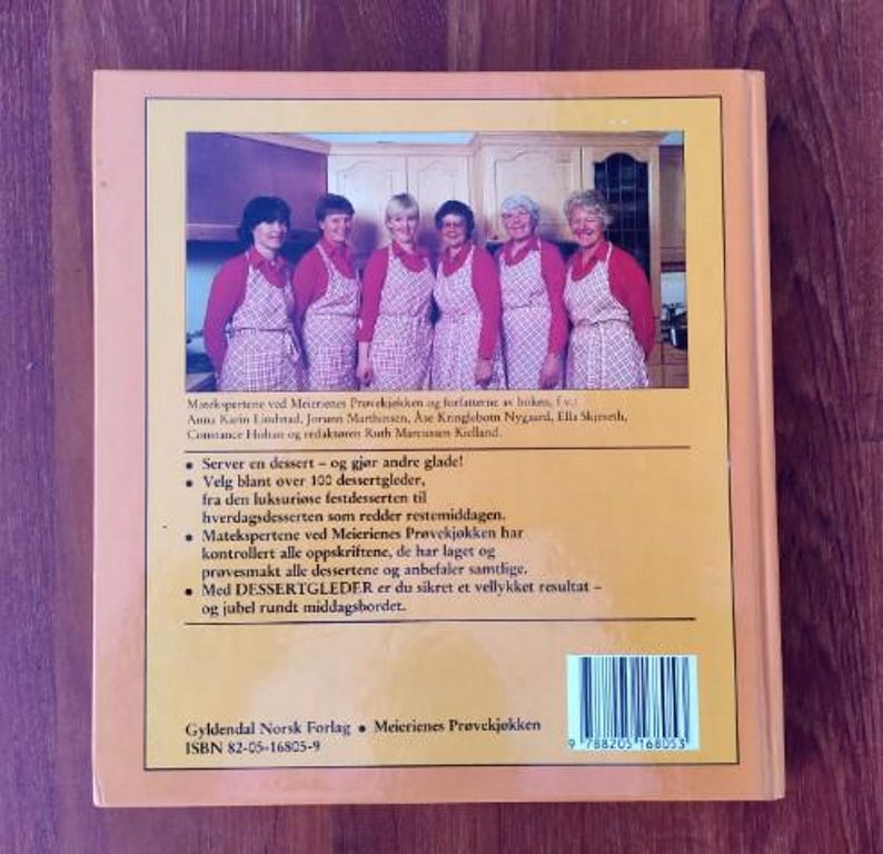 Puede incluir: Una cubierta de libro amarilla con una foto de cinco mujeres en una cocina. El t&iacute;tulo del libro es "Meierienes Pr&oslash;vekj&oslash;kken" y el texto en la parte posterior del libro dice "Server en dessert - og gj&oslash;r andre glade!" El libro est&aacute; publicado por Gyldendal Norsk Forlag.