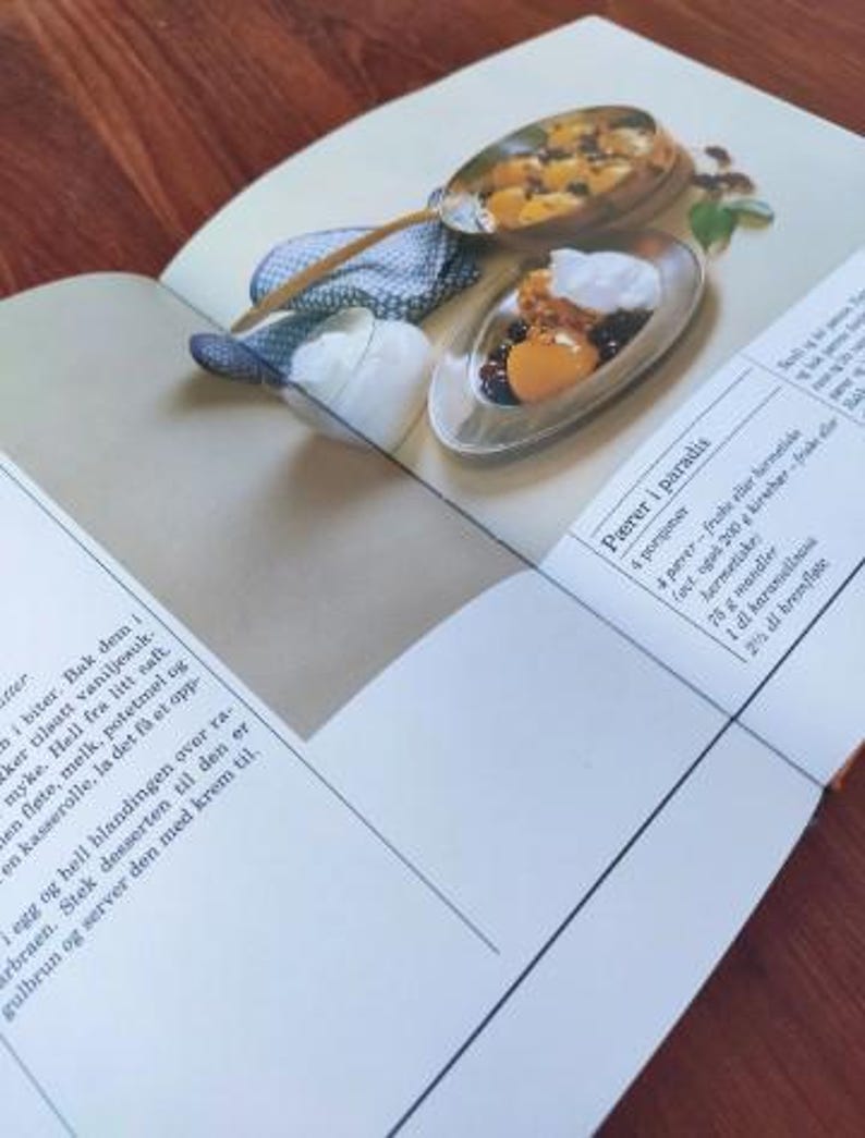 Puede incluir: Un libro de cocina abierto en una receta de peras en el para&iacute;so. La receta requiere 4 peras, 200 gramos de ricotta, 75 gramos de almendras, 100 ml de caramelo y 200 ml de nata.