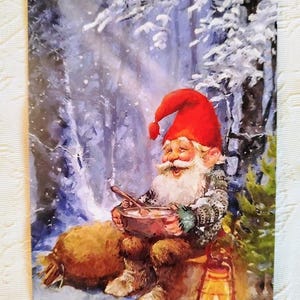 Cartão de Natal nórdico feliz do gnomo - Gnomo sentado no inverno comendo mingau de arroz - Cartões postais de saudação suecos e noruegueses Nisse Tomte