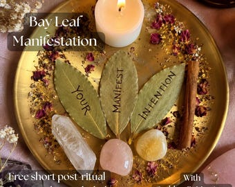 May include: A gold-toned circular tray containing a white candle, three bay leaves inscribed with the words YOUR, MANIFEST, and INTENTION, a clear quartz point, a rose quartz stone, a citrine stone, and a cinnamon stick amidst dried flower petals.