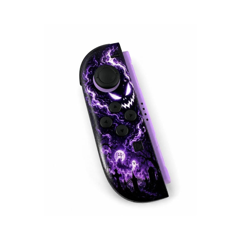 K&ouml;nnte beinhalten: Ein Videospiel-Controller Joy-Con mit einem dunkelvioletten und schwarzen Grafikdesign. Das Motiv zeigt eine gruselige Friedhofsszene mit leuchtendem violettem Nebel, einem Vollmond und einem bedrohlichen Gesicht mit wei&szlig;en Augen und gezacktem Grinsen.