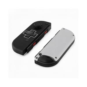 Pode incluir: Um controlador de jogo preto e cinza com um D-pad, bot&otilde;es e um joystick. O controlador tem um design retr&ocirc; com bot&otilde;es vermelhos e uma parte traseira cinza. O controlador &eacute; projetado para jogos.
