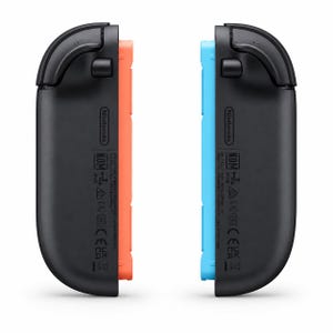 May include: Two black Nintendo Switch Joy-Con controller straps with curved edges. One strap features a bright orange side panel, while the other has a bright blue side panel. Both units display the Nintendo logo and regulatory text markings.