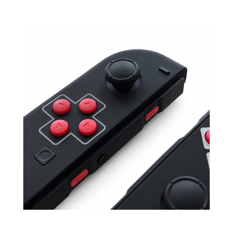 Pode incluir: Controlador de jogo preto com bot&otilde;es vermelhos e um joystick preto. O controlador tem um design retro com um direcional e bot&otilde;es de in&iacute;cio/sele&ccedil;&atilde;o. Os bot&otilde;es s&atilde;o vermelhos e o joystick &eacute; preto.