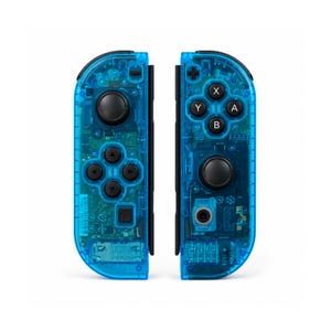 Pu&ograve; includere: Due controller di gioco blu trasparenti con pulsanti e pad direzionali neri. I controller sono progettati per essere collegati a una console di gioco. I componenti interni sono visibili attraverso la plastica traslucida.