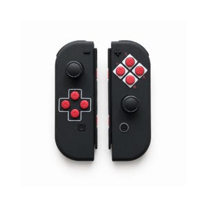 Pode incluir: Dois controles de jogo pretos com bot&otilde;es vermelhos e brancos. Cada controle tem um joystick e um conjunto de bot&otilde;es. Os controles s&atilde;o projetados para um console de jogos e s&atilde;o mostrados em um fundo branco.