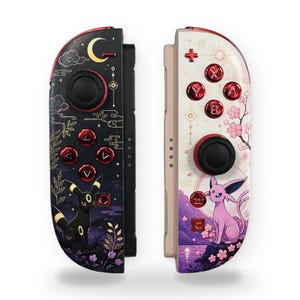 May include: Two game controllers featuring custom designs. The left controller is black with a yellow crescent moon, clouds, and a black creature with yellow rings. The right controller is white with pink cherry blossoms and a pink creature.
