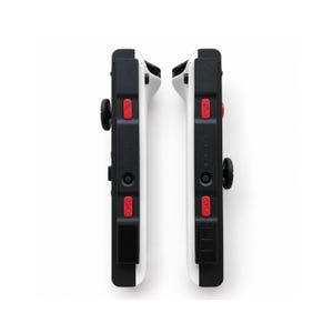 Pode incluir: Dois controles de jogo em preto e branco com bot&otilde;es vermelhos e joysticks pretos. Os controles t&ecirc;m as letras "SR" e "SL" impressas. Os controles s&atilde;o projetados para um console de jogos.