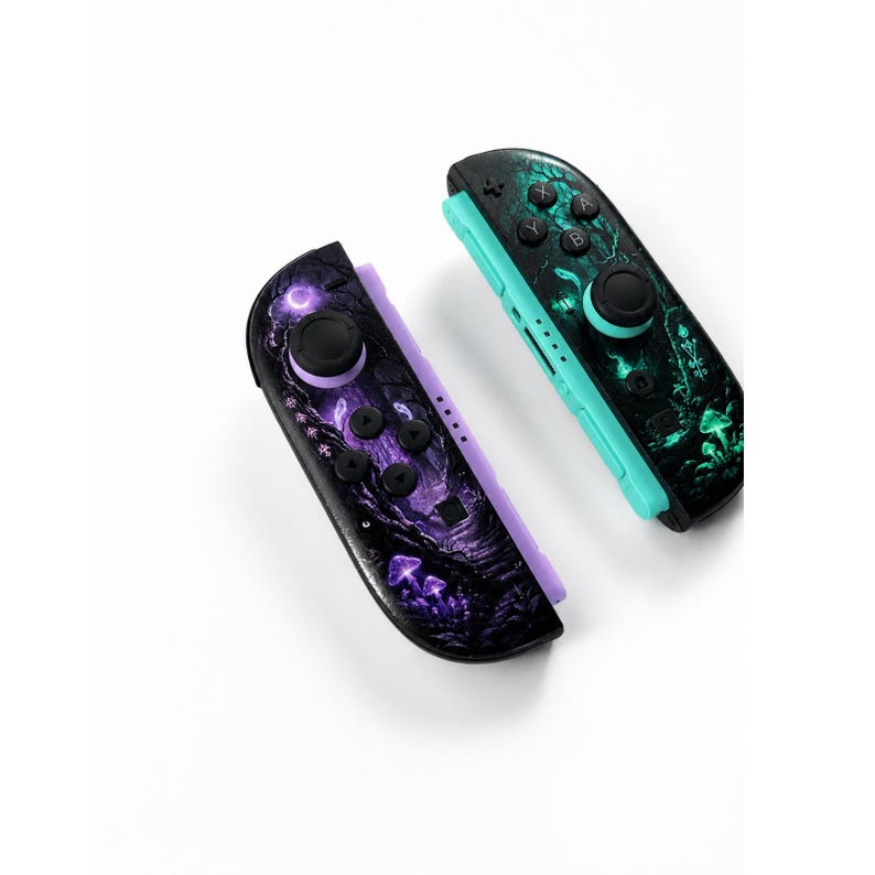 May include: Two wireless game controllers featuring a dark forest theme. The left controller has purple accents and a purple mushroom design, while the right controller has teal accents and a green mushroom design with black buttons and joysticks.