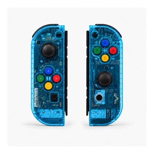 Pu&ograve; includere: Due controller di gioco blu trasparenti con componenti interni visibili. Ogni controller ha joystick neri, pulsanti colorati (rosso, blu, verde, giallo) e un D-pad. I controller sono progettati per il gaming.