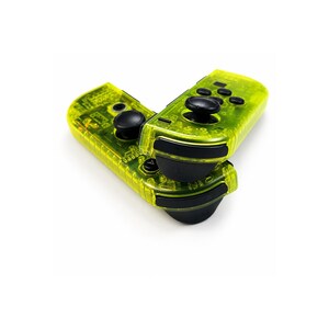 May include: Two neon yellow video game controllers with a transparent shell design. Each controller features black analog sticks, black shoulder buttons, and a set of black circular action buttons. The internal electronic components are visible.
