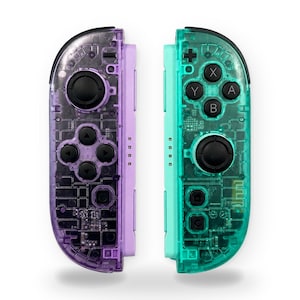 May include: A pair of wireless game controllers featuring a transparent purple shell on the left and a transparent teal shell on the right. Both controllers include black analog sticks, directional buttons, and action buttons with visible internal circuitry.