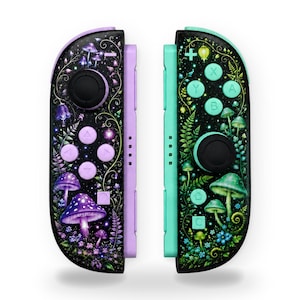 Op de afbeelding: Een paar gamecontrollers met een zwarte basis en een levendig bosbodemontwerp. De linkercontroller heeft lavendelkleurige accenten en paarse paddenstoelillustraties, terwijl de rechtercontroller mintgroene accenten en groene paddenstoelafbeeldingen heeft.