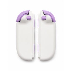 Puede incluir: Dos accesorios de mando de juego blancos con bordes redondeados y detalles en color lavanda en los botones superiores y laterales. Estos accesorios de juego rectangulares tienen un acabado liso y est&aacute;n colocados verticalmente uno al lado del otro.