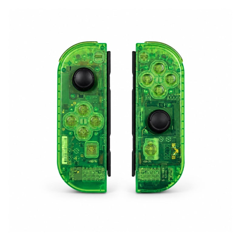 May include: Two neon green game controllers, each with a black joystick and buttons. The transparent design reveals the internal circuitry. The controllers are designed for a gaming console.