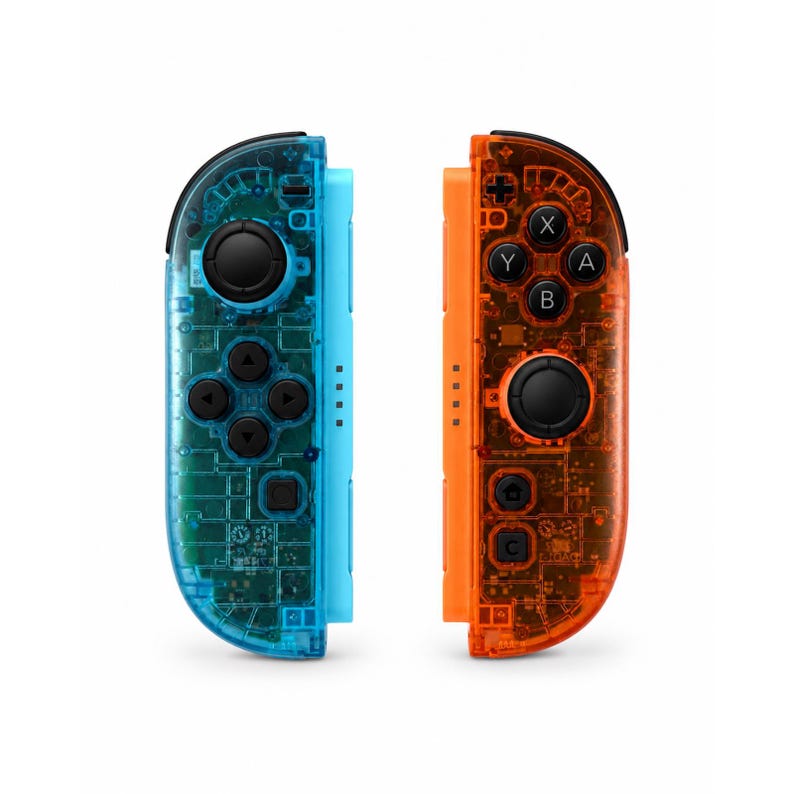 May include: A pair of wireless game controllers featuring a transparent blue shell on the left and a transparent orange shell on the right. Both controllers include black analog sticks, directional buttons, and action buttons labeled A, B, X, and Y.