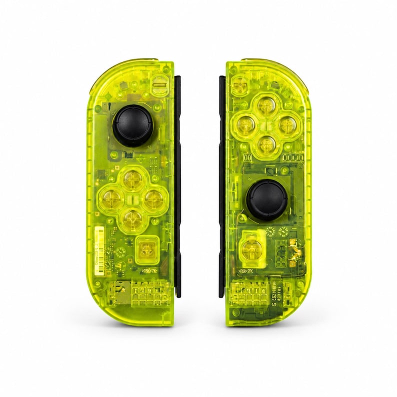 May include: A pair of neon yellow game controllers with a transparent casing that reveals the internal electronic components, including circuit boards, buttons, and black joysticks. The controllers feature a four-button directional pad layout.