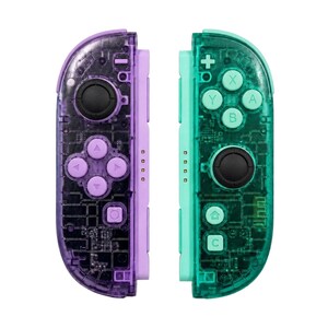 May include: A pair of wireless game controllers featuring a transparent purple and green shell design. The left controller has a black joystick and purple directional buttons, while the right controller has a black joystick and green A, B, X, Y buttons.