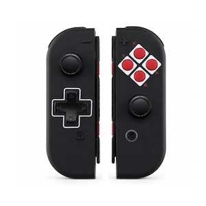Pode incluir: Controlador de jogos preto com bot&otilde;es vermelhos e brancos. O controlador tem um direcional, bot&otilde;es rotulados X, Y, A e B e outros elementos de controle. O design lembra um console de jogos cl&aacute;ssico.