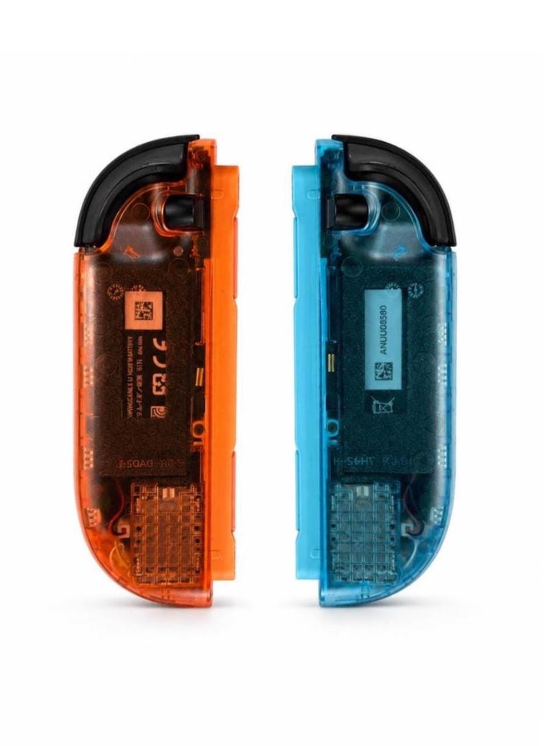 May include: A pair of video game controllers featuring a translucent orange shell on the left and a translucent blue shell on the right. Both controllers have black top buttons and internal components visible through the casing, including printed text and QR codes.