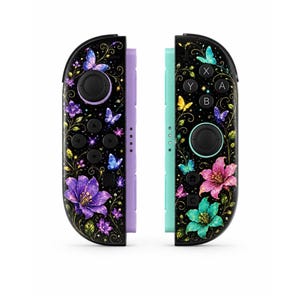May include: Two game controllers featuring a black base with a vibrant floral and butterfly pattern. The left controller has a light purple side rail, while the right controller has a light teal side rail. Both display colorful lilies and butterflies.