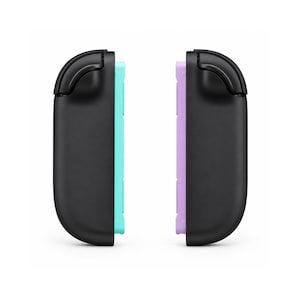 May include: Two black controller strap attachments for a gaming console. The left attachment features a bright turquoise inner rail, while the right attachment features a light lavender inner rail. Both have a curved top and a matte finish.