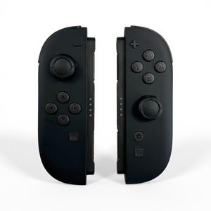 May include: A pair of matte black wireless game controllers featuring a directional pad, a circular analog stick, a minus button, and a square capture button on the left unit, with a plus button, four lettered action buttons, an analog stick, a home button, and a square button on the right.
