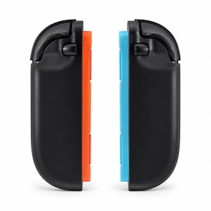 May include: Two black gaming controller attachments, each featuring a curved outer shell and a top shoulder button. One attachment has a bright orange inner side, while the other has a bright blue inner side, both designed for handheld gaming consoles.
