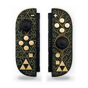 以下が含まれることがあります： 金色のボタンと緑の蔦や木のレリーフデザインが施された黒いゲームコントローラーのペア。左側のコントローラーには幾何学的なグリッドと金色の三角形のエンブレムがあり、右側のコントローラーには木のデザインと金色の三角形のエンブレムが描かれています。