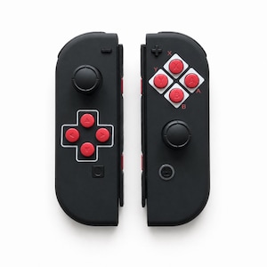 Pode incluir: Controlo de jogo preto com bot&otilde;es e direcional vermelho. O controlo tem um design retro com um joystick circular e um layout de bot&otilde;es quadrados. O controlo foi concebido para jogos.