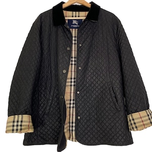 Peut inclure: Une veste matelassée noire avec un col en velours noir et une doublure à carreaux beige, noir et rouge. La veste présente une fermeture à boutons-pression sur le devant et des manches longues avec des poignets repliés révélant le motif.