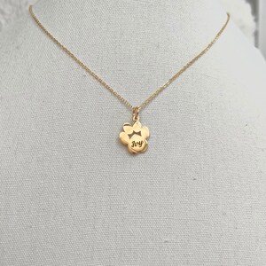 May include: Gold necklace with a paw print pendant that says "Ivy" on it.