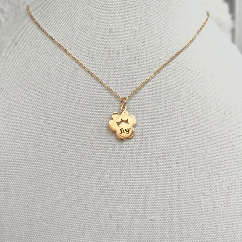 May include: Gold necklace with a paw print pendant that says "Ivy" on it.