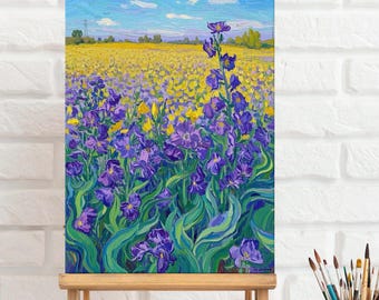 May include: A painting on a wooden easel depicts a field of purple wildflowers with yellow flowers in the background. The sky is blue with white clouds.