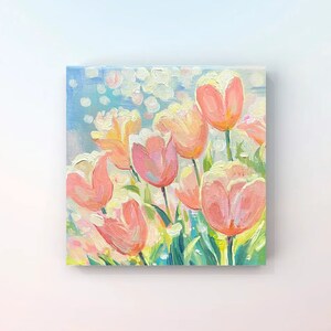 May include: A painting of a bouquet of pink and white tulips against a light blue background with white dots. The tulips are painted in a loose, impressionistic style.