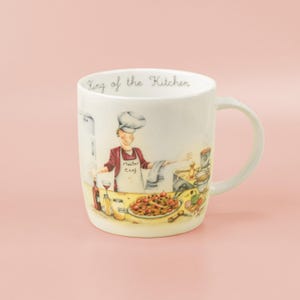 May include: Cream-coloured ceramic mug featuring a kitchen scene with a chef wearing a chef's hat and apron. The mug has the text "King of the Kitchen" printed on the rim. The illustration includes food and kitchen utensils.