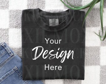 May include: A black t-shirt with the text "Your Design Here" on a white and gray checkered background.