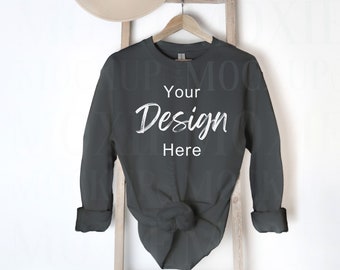 May include: A dark gray long-sleeved shirt with a knotted front, hanging on a wooden ladder. The shirt has the text "Your Design Here" printed on the front.