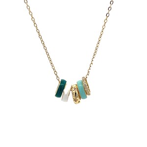 May include: A gold-colored necklace featuring five decorative rings. The rings are in various colors, including teal, white, and gold, with some adorned with small star and crystal accents. The necklace has a delicate chain.