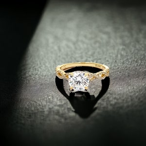 May include: A gold engagement ring with a large, round, clear diamond center stone. The band is twisted and features smaller diamonds.
