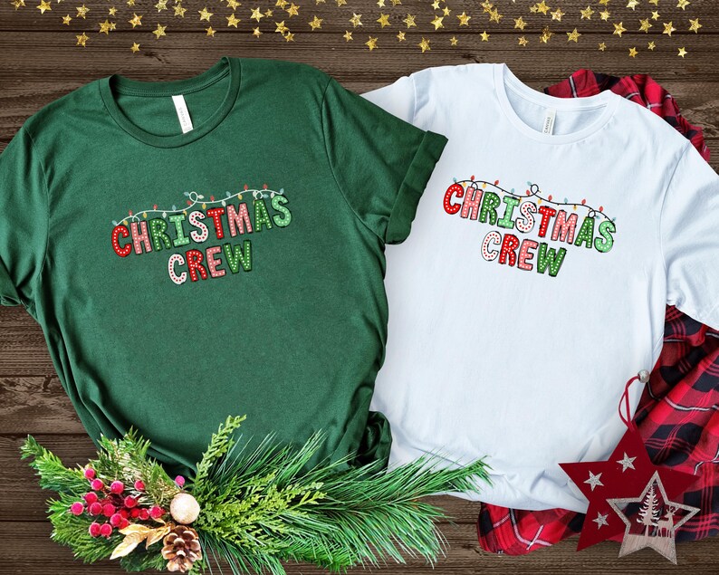 May include: Two green and white t-shirts with the text "Christmas Crew" in red, green, and white letters with a string of Christmas lights above the text.